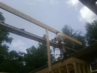 Carpenter setting a ridge beam over a new addition frame — Ice Dam Removal by Roofing Brothers in Round Top