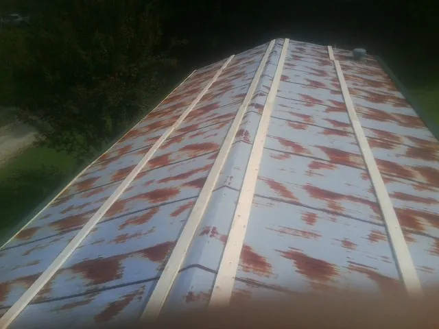 Rusted metal roof panels with new wood purlins before replacement — Storm Damage Roof Repair in Round Top by Roofing Brothers